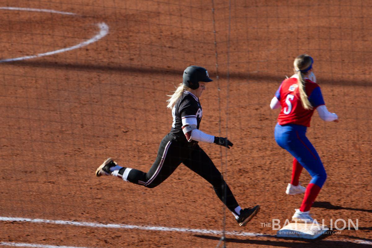 Senior pitcher and outfielder Makinzy Herzog (24) runs to first base while Kansas sophomore infielder Kaitlyn Gee (5) prepares to catch the ball in Davis Diamond on Friday, Feb. 18, 2022.