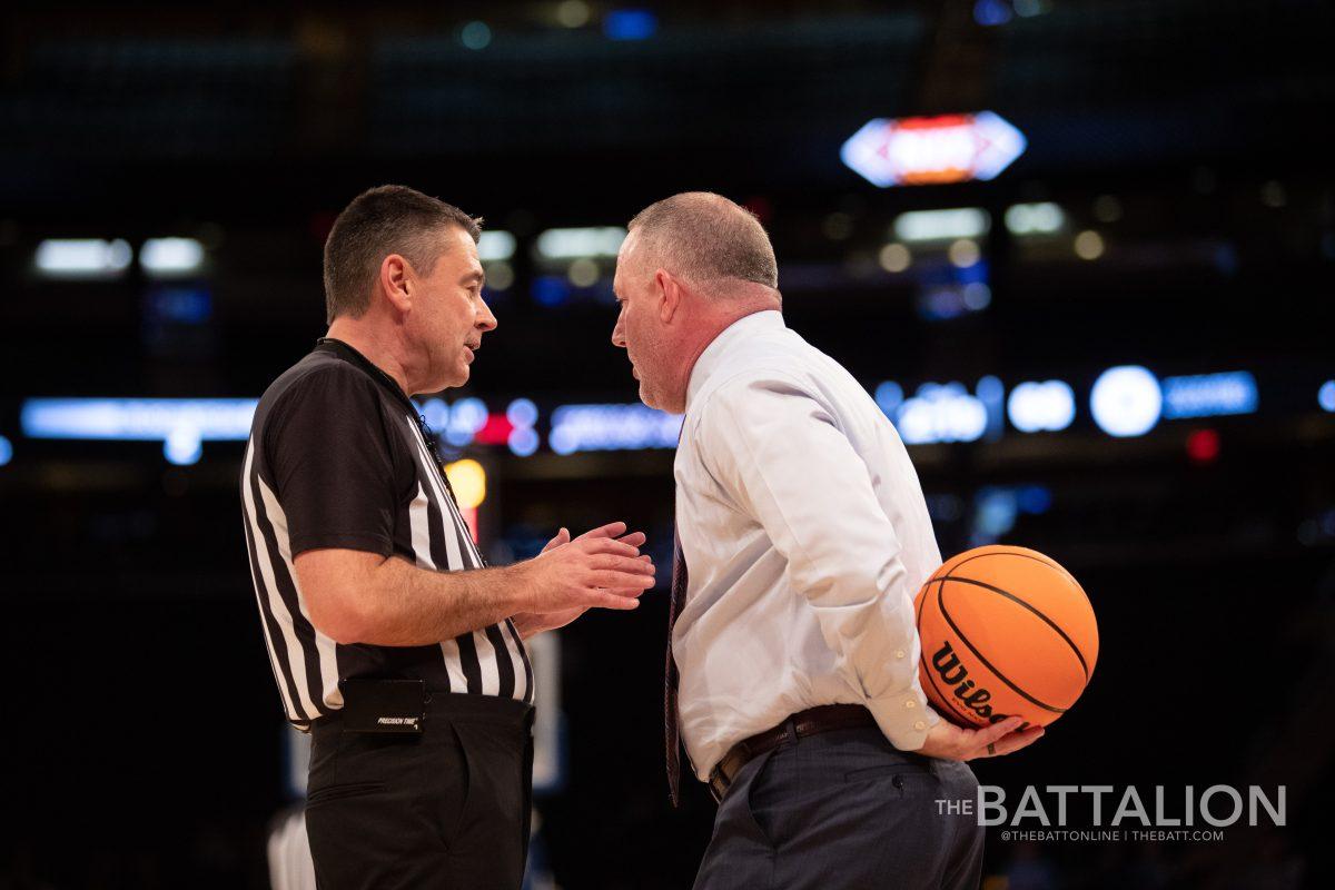Texas A&M head coach Buzz Williams holds the game ball while a referee explains a penalty call in Madison Square Garden on Thursday, March 31, 2022.