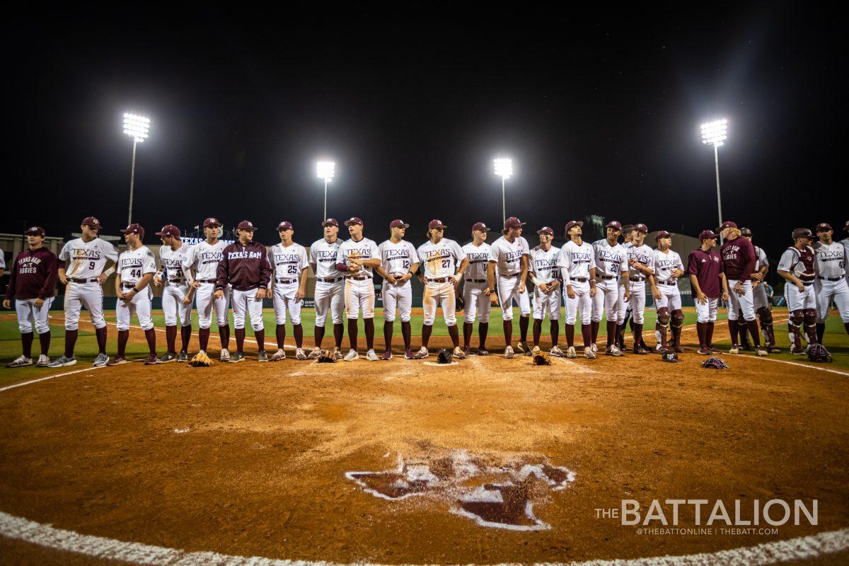 The Aggies line up by home plate to sing the Aggie War Hymn in Olsen Field on Tuesday, April 19, 2022.