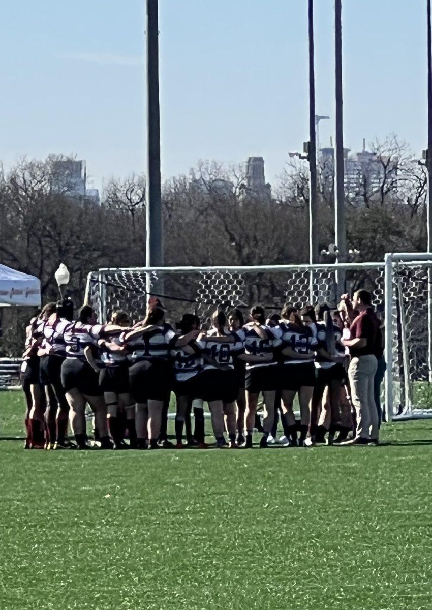 Aggie Ruggers huddle together.