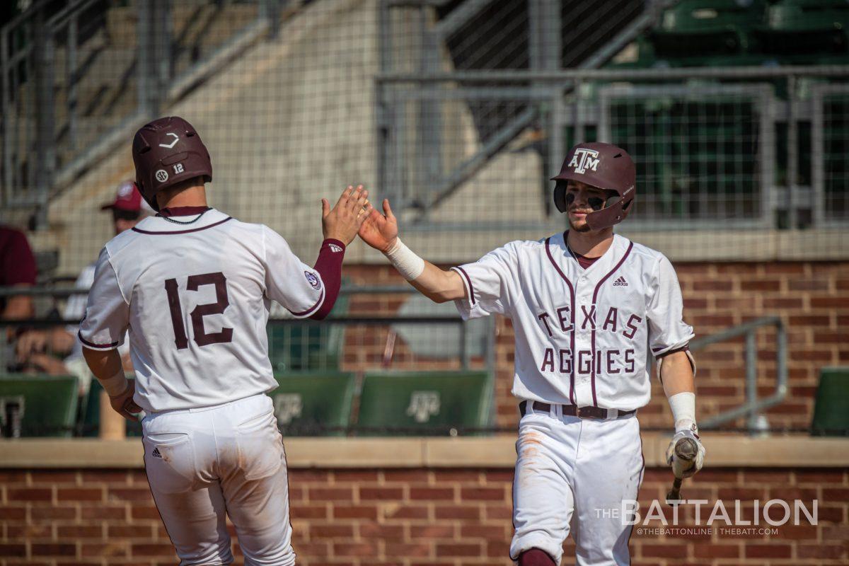 <p>Senior C Troy Claunch (12) is congratulated by senior Rody Barker (2) who was warming up to pinch hit for graduate SS Kole Kaler (1) in the bottom of the seventh inning at Olsen FIeld on Saturday, May 7, 2022.</p>