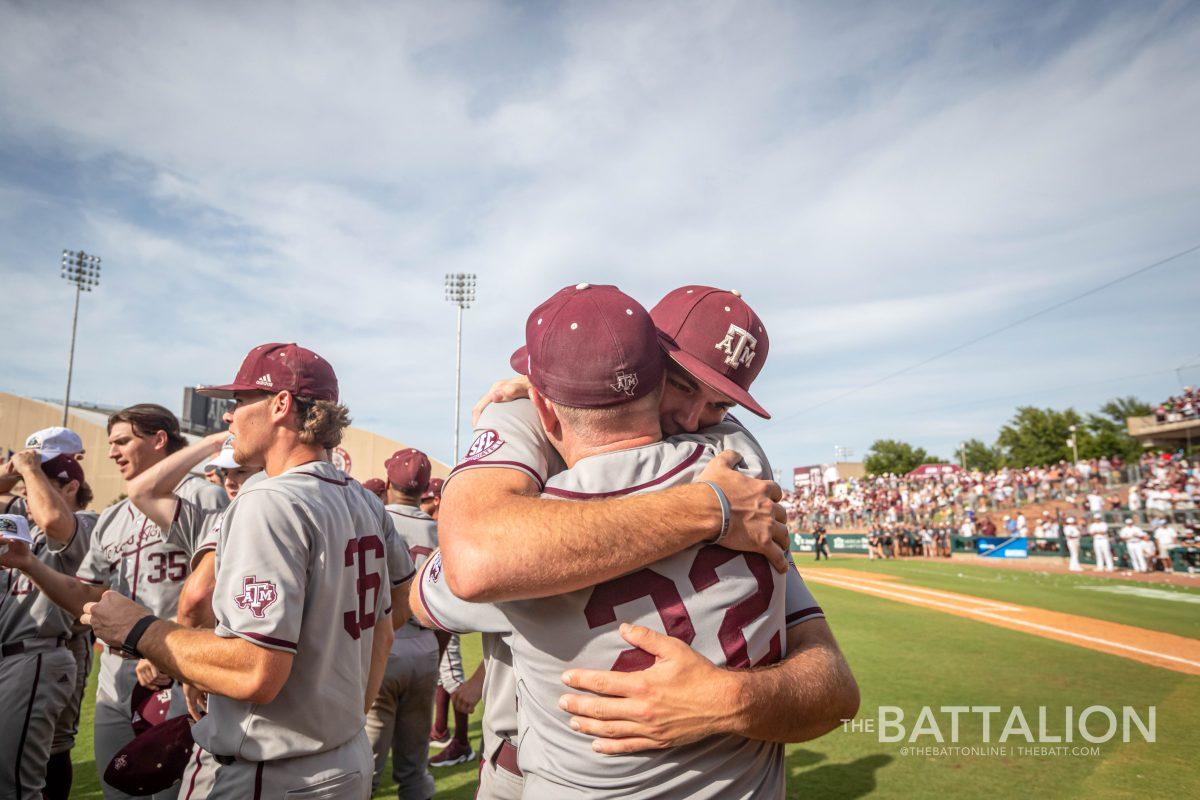 A&M head coach Jim Schlossnagle hugs graduate LHP Jacob Palisch (33) after the Aggies win over Louisville on Saturday, June 11.