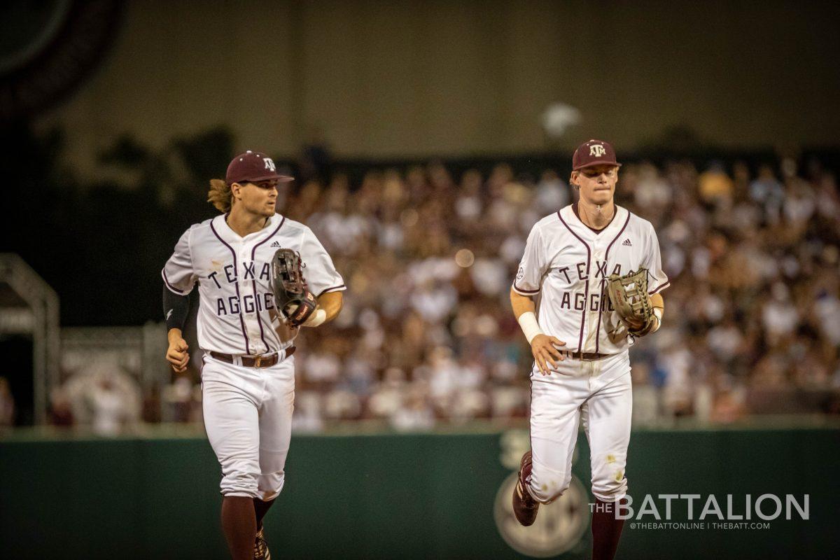 Graduate LF Dylan Rock (27) and junior RF Brett Minnich (23) run to the dugout after the end of the top of the 5th inning at Olsen Field on Friday, June 10, 2022.