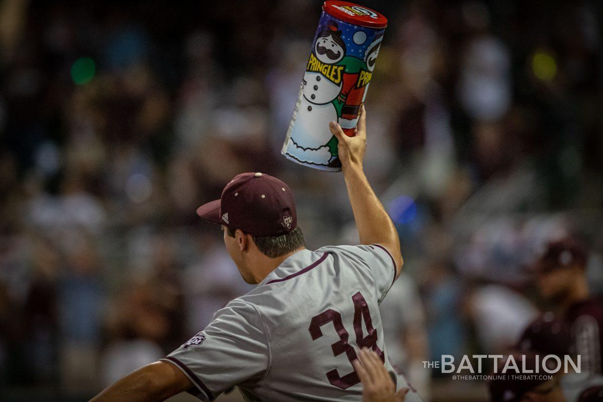 Junior RHP Micah Dallas (34) lifts a large can of Pringles into the air at Olsen Field on Sunday, June 5, 2022.