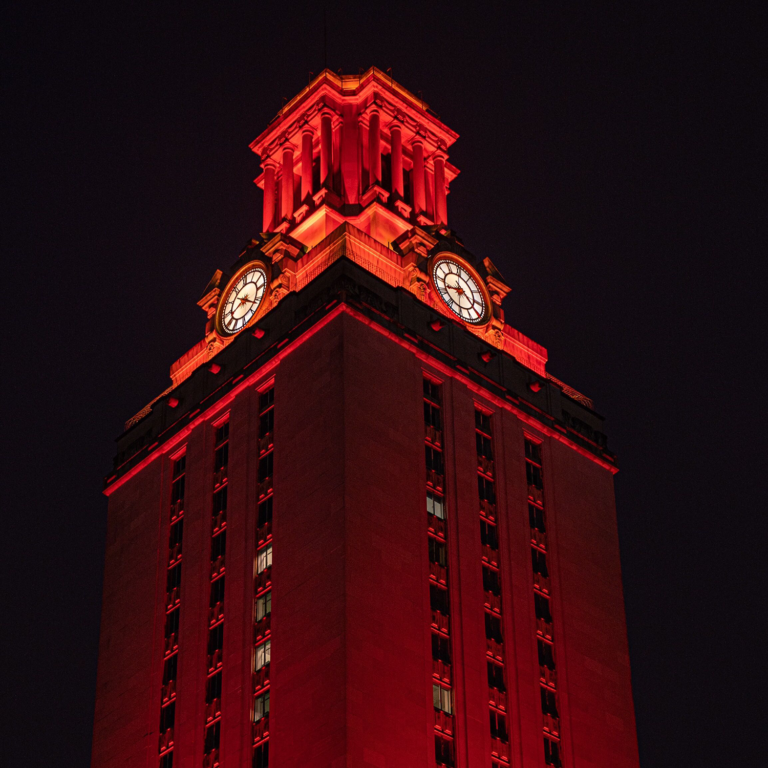 <p>The Main Building at the University of Texas, lit orange at night.</p>