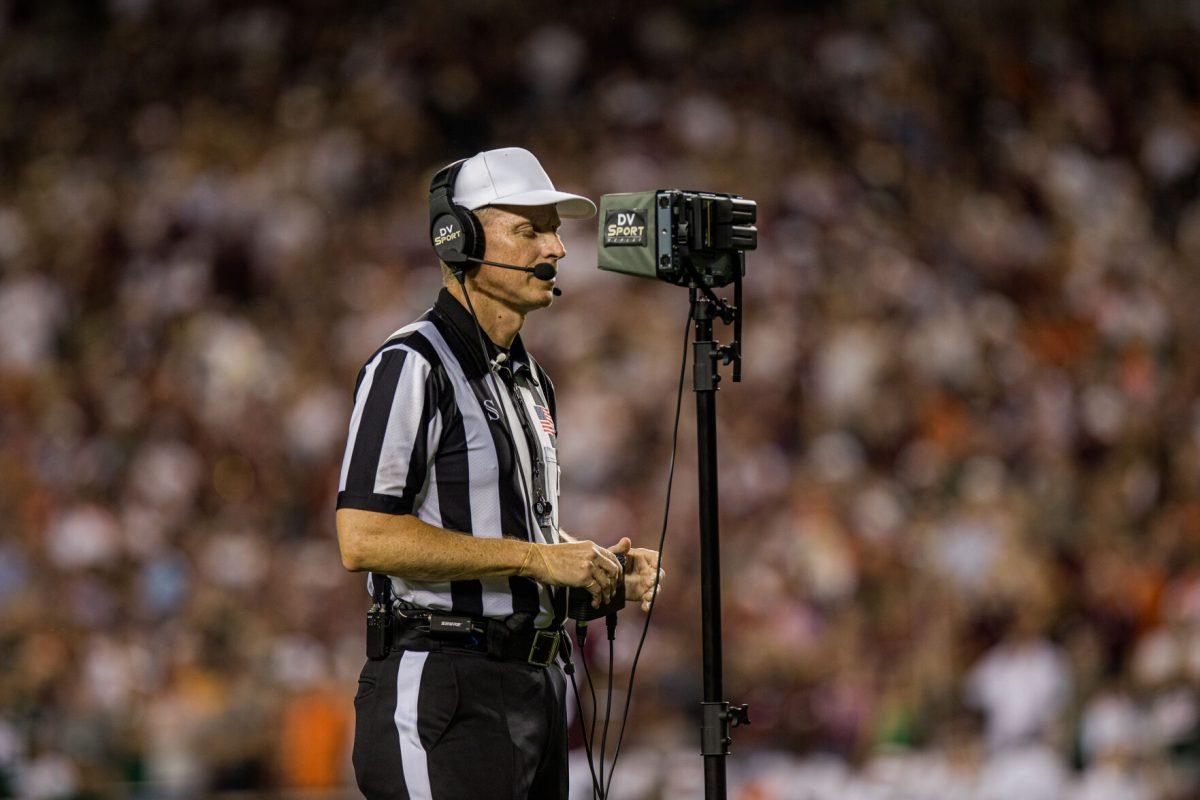 The referee reviews video replay of a challenged play during Texas A&M's game against Miami at Kyle Field on Saturday, Sept. 17, 2022.