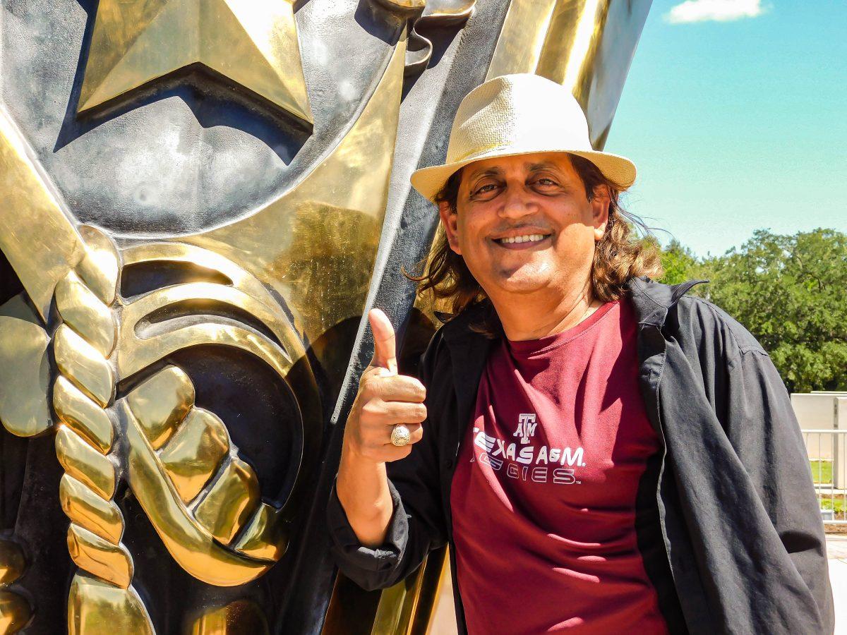 <p>Kreshna Gopal, Class of 2000, poses with his ring at the Haynes Aggie Ring sculpture on Sunday, Sept. 25, 2022.</p>