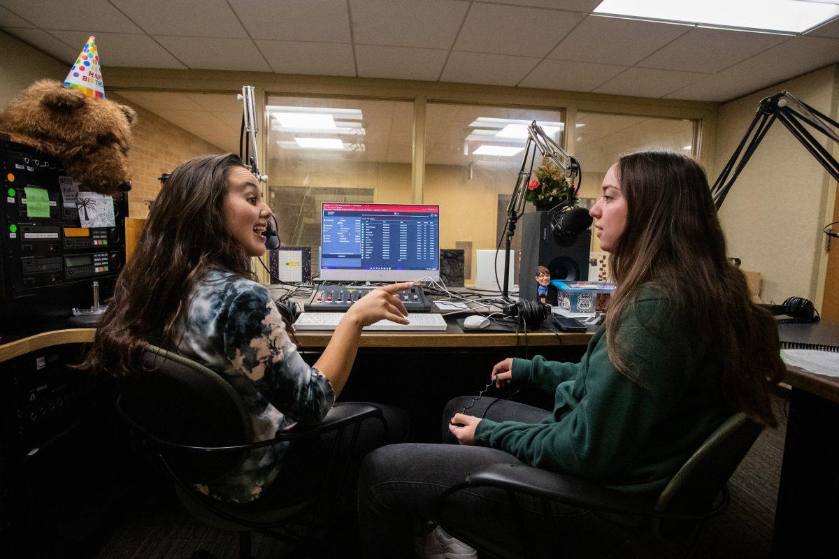 Wynn Wynn and Camille Borja, hosts of the radio show The Highs and The Lows, talk in the KANM recording studio on Monday, Oct. 3, 2022.