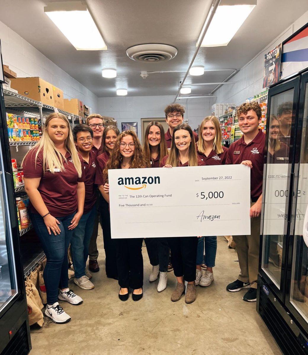 Members of The 12th Can food pantry present their $5,000 check from Amazon at their office in the Mail Services Building on Sept. 27, 2022.