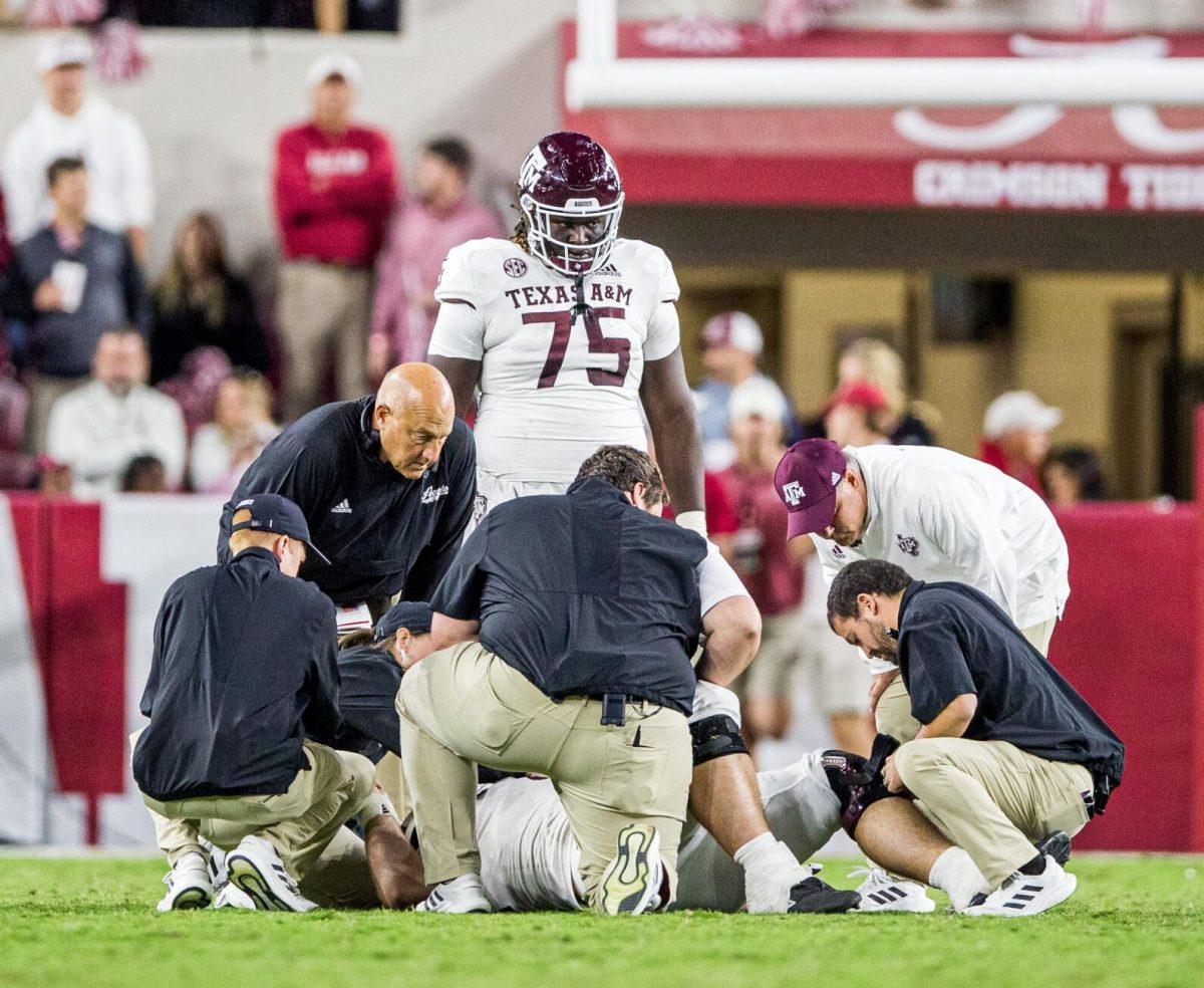 A&M football staff gather around Bryce Anderson (1) after an ingury during the game against the Alabama Crimson Tide on Saturday, Oct. 8, 2022, at Bryant-Denny Stadium in Tuscaloosa, Alabama.
