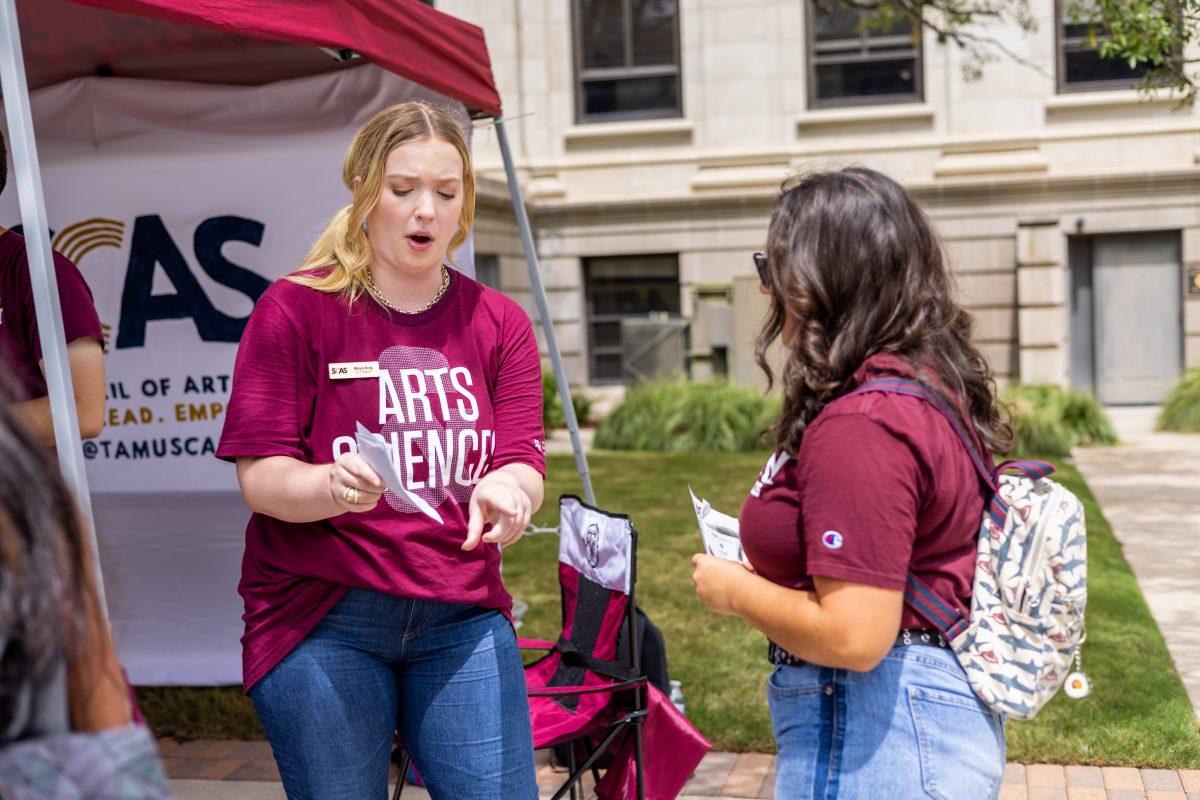 <p>Senior Alexis King talks with a student at the College of Arts & Sciences Launch Party in the East Quad on Tuesday, Aug. 23, 2022.</p>