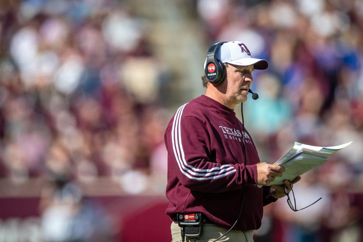 Texas A&M coach Jimbo Fisher looks through a playbook from the sideline during A&Ms game against Florida at Kyle Field on Saturday, Nov. 5, 2022.