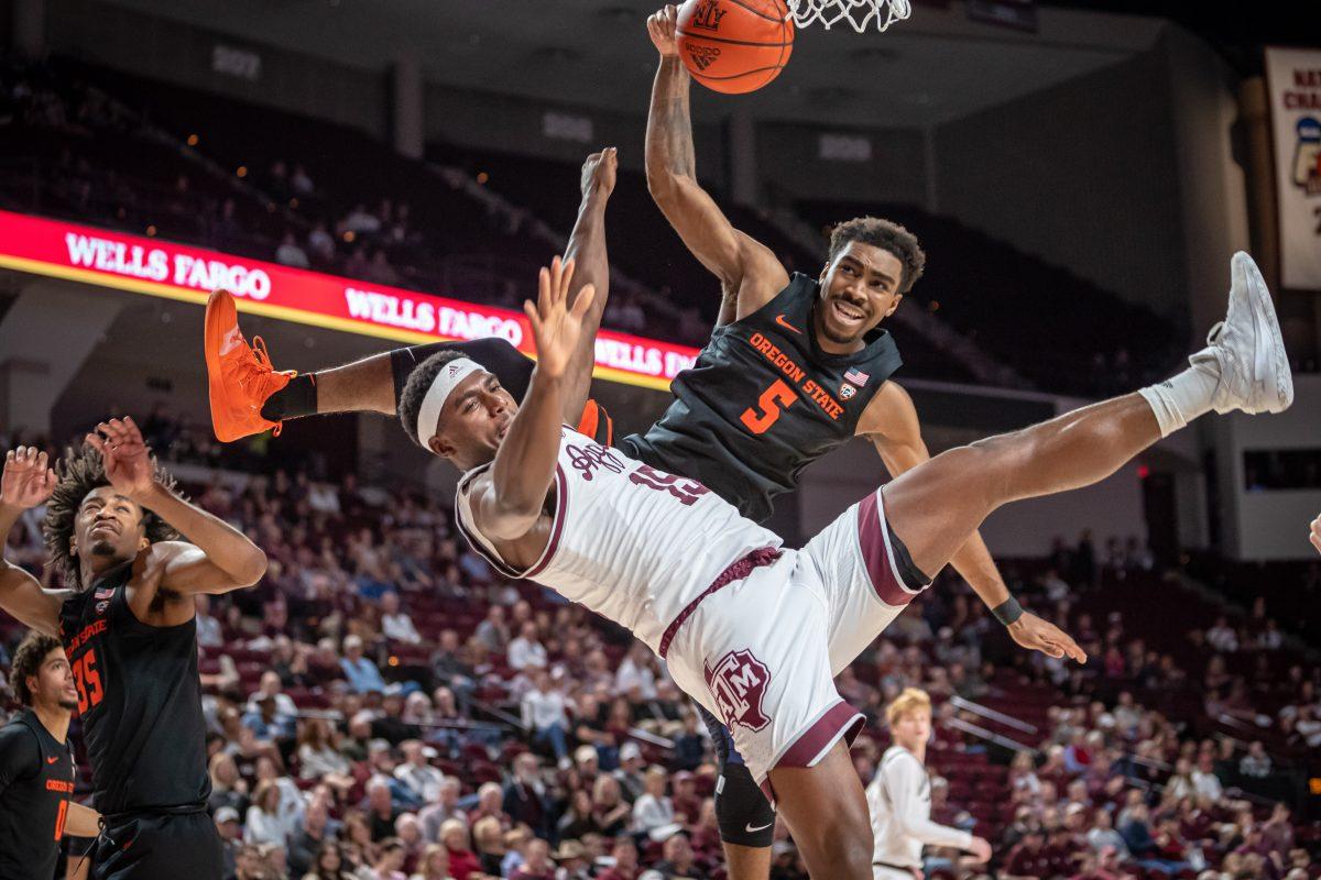 Junior F Henry Coleman III (15) is knocked to the ground after jumping to shoot a layup during Texas A&amp;M's game against Oregon State at Reed Arena on Sunday, Dec. 11, 2022.