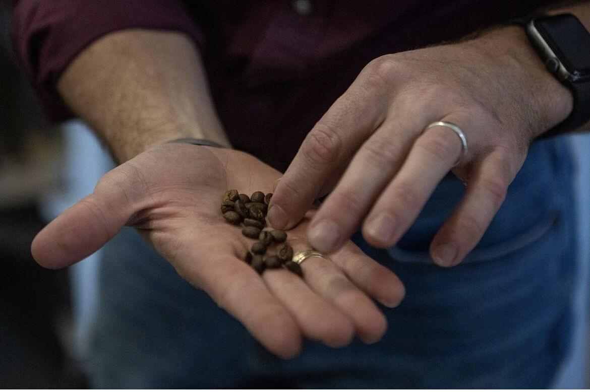 Steve Turner holds out freshly roaster coffee beans. 