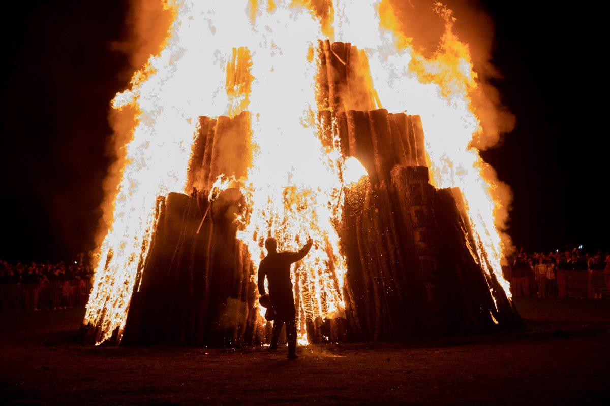 <p>Torch runner tosses fallen torch at the Student Bonfire on Saturday, Jan. 21, 2023.</p>