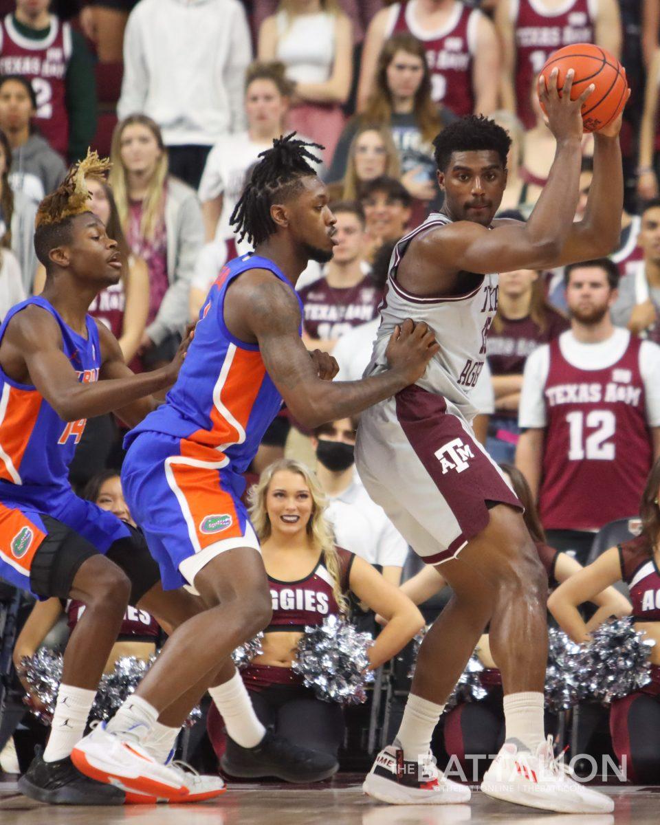 Sophomore forward Henry Coleman III (15) holds the ball away from Florida defenders in Reed Arena on Tuesday, Feb. 15, 2022.