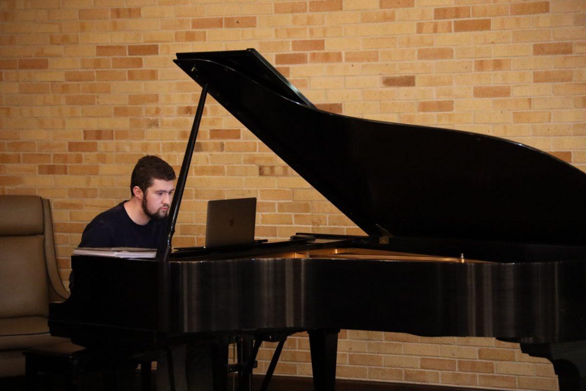 A student plays the grand piano in the MSC Flag room. 