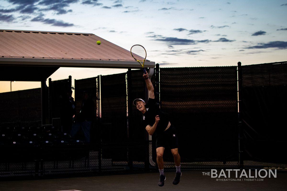 Sophomore Kenner Taylor serves the ball during a doubles match against the University of Texas at the Mitchell Tennis Center on Wednesday, Mar. 9, 2022.