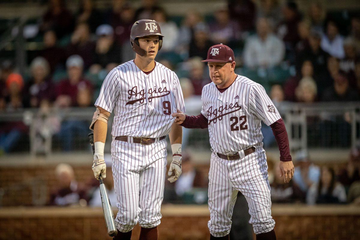 A&M coach Jim Schlossnagle (22) pulls junior 1B Jack Moss (9) back to the dugout after Moss began arguing with home plate umpire Brandon Tipton during Texas A&Ms game against Portland at Olsen Field on Friday, Feb. 24, 2023.