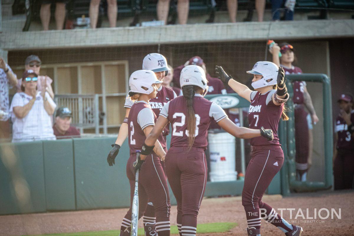Freshman Katie Dack (7) celebrates with her teammates after scoring in the bottom of the third in Davis Diamond on Wednesday, April 27, 2022.
