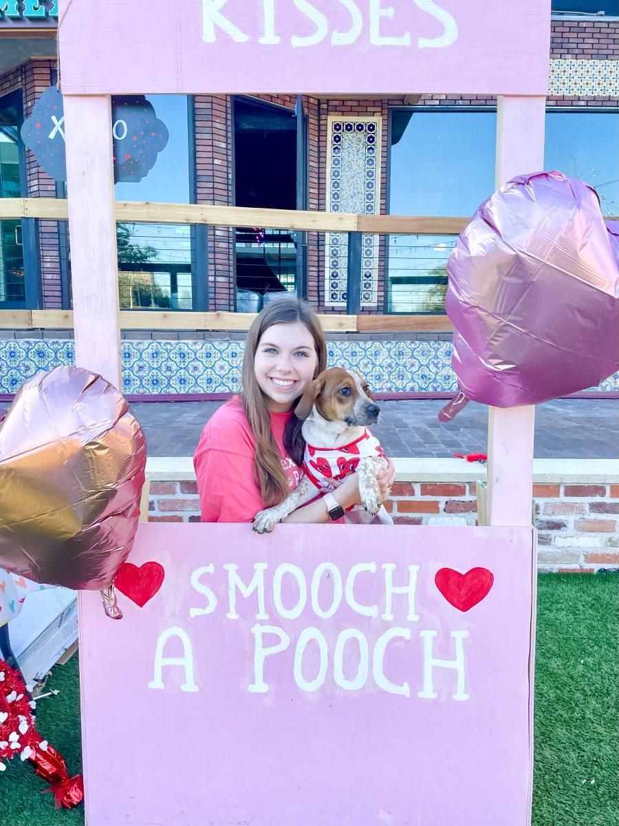 A student stands with a dog during PAWS annual Smooch A Pooch event in 2022. 