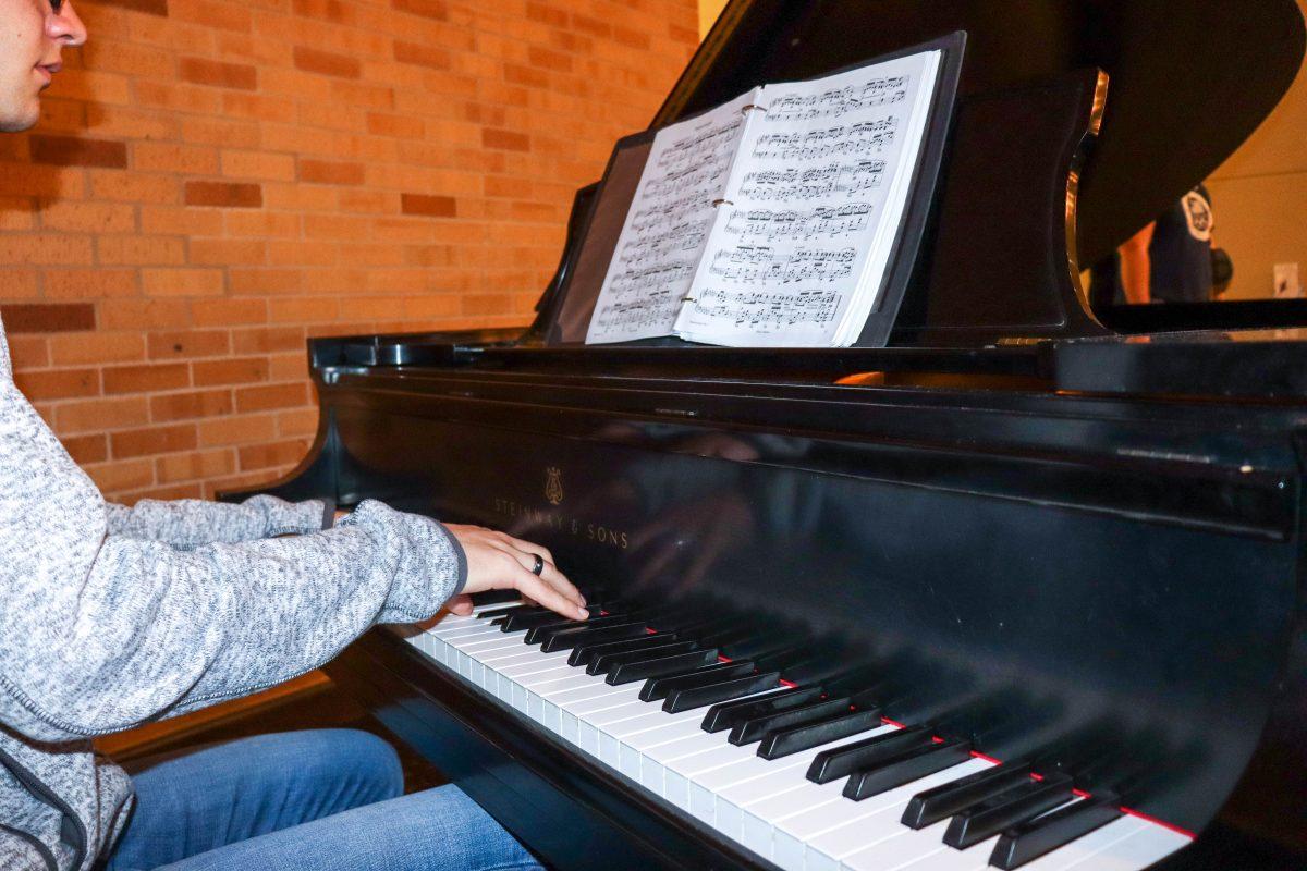 Student freshman Daniel Warren playing the piano at the flag room on Feb. 12, 2023