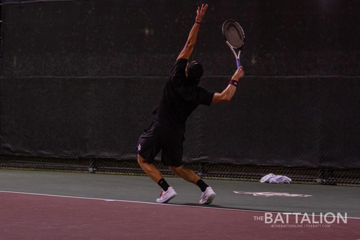 Sophomore Matthis Ross serves a ball to Eliot Spizzirri from the University of Texas at the Mitchell Tennis Center on Wednesday, Mar. 9, 2022.