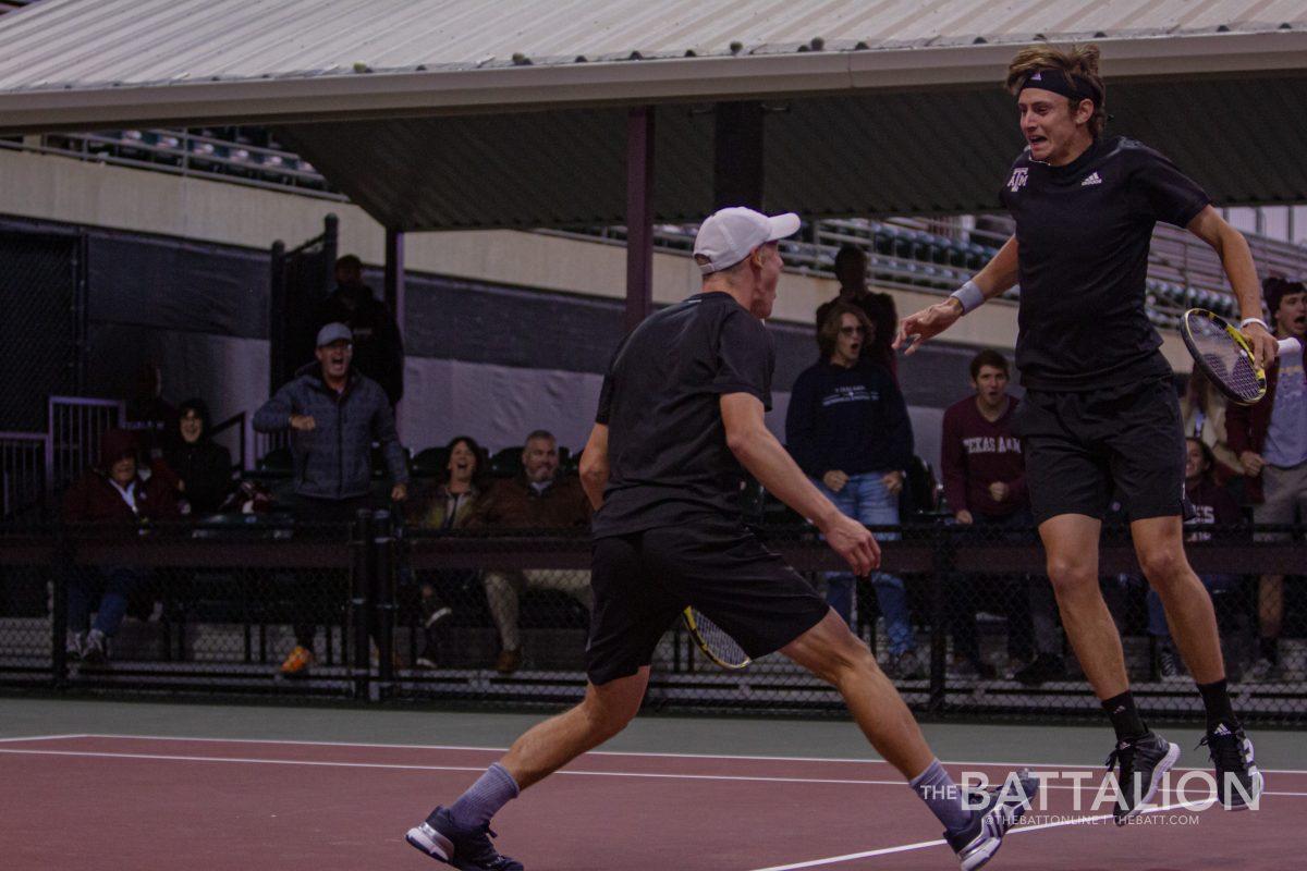 <p>Junior Noah Schachter and sophomore Kenner Taylor celebrate after winning their doubles match against the University of Texas at the Mitchell Tennis Center on Wednesday, Mar. 9, 2022.</p>