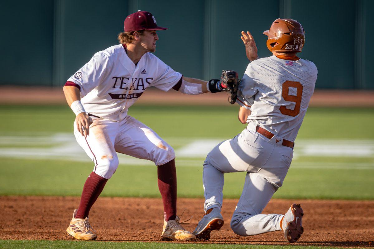 Junior SS Hunter Haas (2) tags Texas 1B Jared Thomas (9) for an out during Texas A&Ms game against Texas at Olsen Field on Tuesday, March 28, 2023.