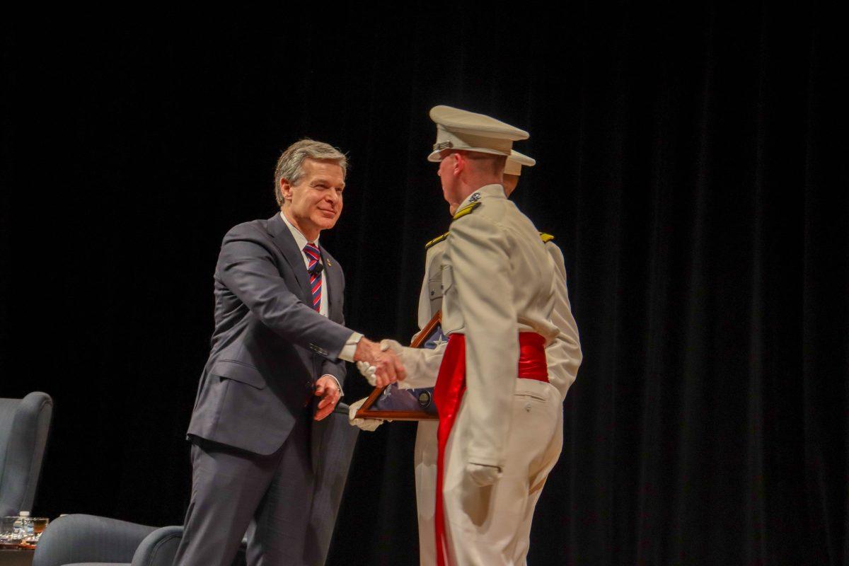 FBI Director Christopher Wray receives the flag that flew during the 25th anniversary of the Bush School during the A Conversation with the Director of the FBI event at the Annenberg Presidential Conference Center on Wednesday, April 5, 2023.