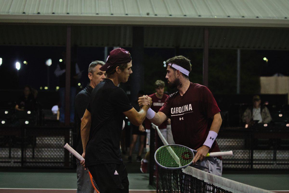 <p>Junior Pierce Rollins shakes hands with opponent South Carolina Junior Connor Thomson after the first loss against South Carolina at the Mitchell Outdoor Tennis Center on April 13, 2023.</p>