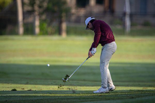 Sophomore Michael Heidelbaugh plays a shot on the first hole of the Traditions Club on the second day of the Aggie Invitational on Tuesday, April 11, 2023.