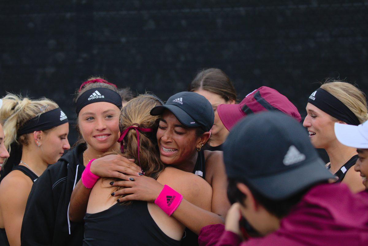 Graduate Student Salma Ewing is congratulated by her team after a hard fought match at the Mitchell Outdoor Tennis Center on April 2, 2023.