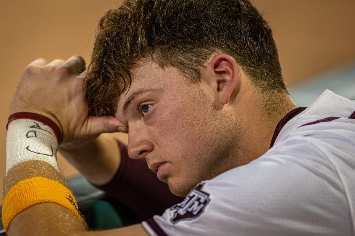 Junior 1B Jack Moss (9) sits in the dugout after Texas A&amp;M's loss to Florida at Olsen Field on Friday, May 5, 2023.