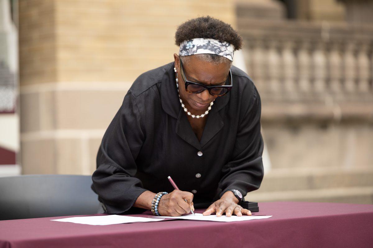 Kathleen McElroy, Ph.D, signs her first offer letter in front of students, professors and faculty outside the academic building on Tuesday, June 13, 2023.