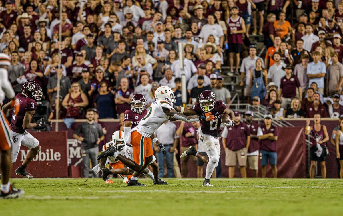 Senior WR Ainias Smith (0) stiff arms Miami DB James Williams (0) during Texas A&amp;M's game against Miami at Kyle Field on Saturday, Sept. 17, 2022.