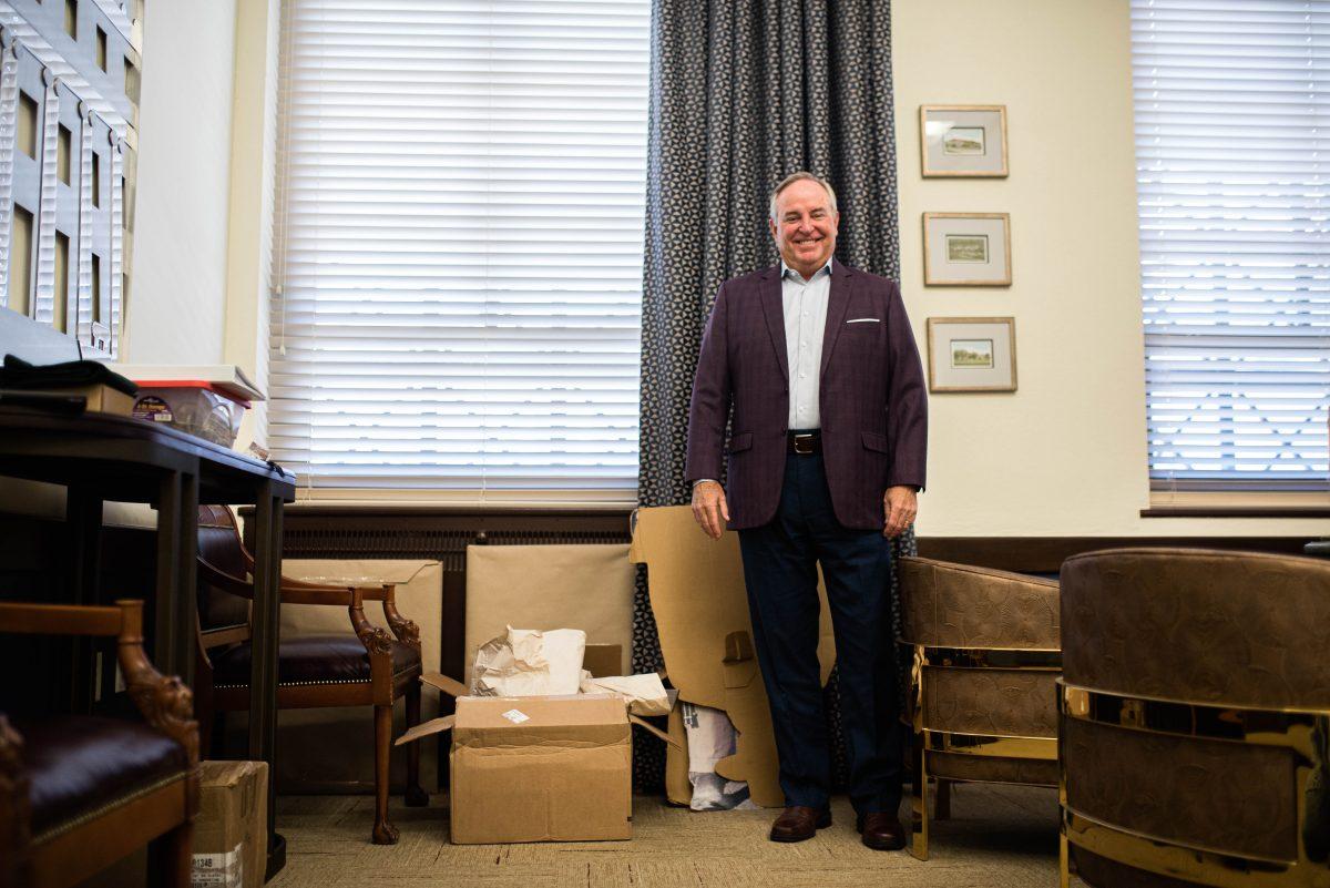 Interim President Mark A. Welsh III stands for a photo in his office with a pile of boxes inside the Jack K. Administration Building on Wednesday, Aug. 2, 2023.