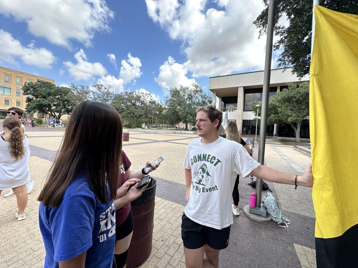 JOUR 203 reporters interview Neil Yows as he banners near Rudder Tower on Sept. 5 at 11:46 a.m.