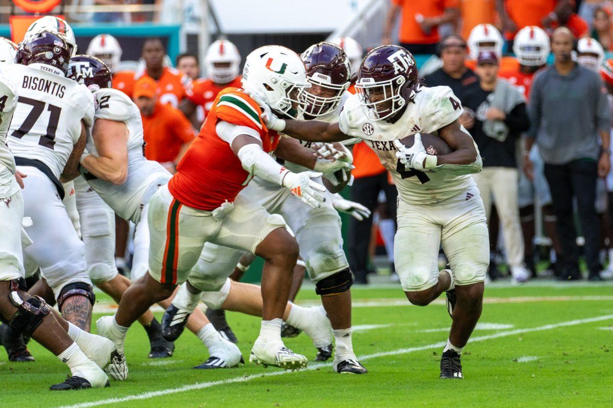 Junior RB&#160;Amari Daniels (4) carries the ball pushing Hurricane LB Corey Flagg (11) during Texas A&amp;M's game against Miami on Saturday, Sept. 9, 2023 in Miami Gardens, Fla.&#160;