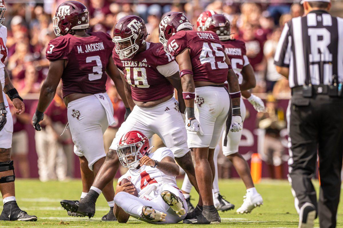 SOphomore DL LT Overton (18) cebebrates after a sack while junior LB Edgerrin Cooper (45) looks down on Alabama QB Jalen Milroe (4) during Texas A&amp;M's football game against Alabama at Kyle Field on Saturday, Oct. 7, 2023. (Chris Swann/The Battalion)