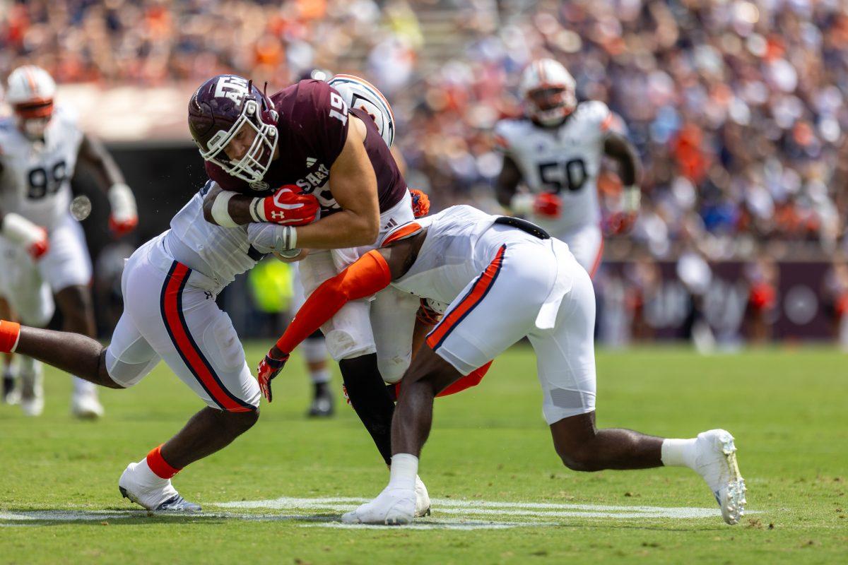 Sophomore TE Jake Johnson (19) runs through two Auburn defenders for a first down catch during Texas A&amp;M's game against Auburn on Saturday, Sept. 23, 2023 at Kyle Field. (CJ Smith/The Battalion)