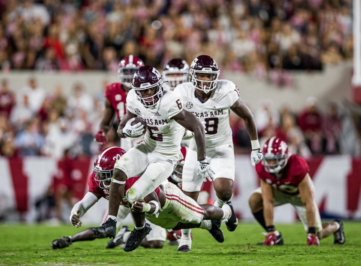 <p>With defense on his back, junior RB Devon Achane (6) runs with the ball during a game against the Alabama Crimson Tide on Saturday, Oct. 8, 2022, at Bryant-Denny Stadium in Tuscaloosa, Alabama.</p>