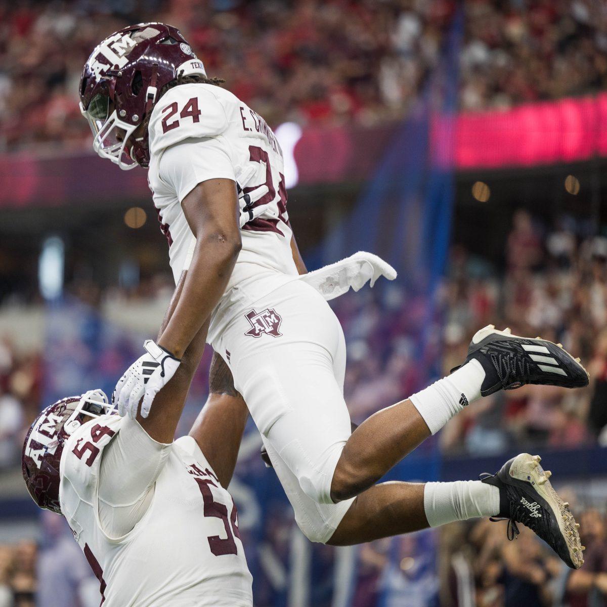 Freshman OL Mark Nabou (54) celebrates with graduate RB Earnest Crownover (24) during the Southwest Classic against Arkansas at AT&amp;T Stadium on Saturday, Sept. 30, 2023. (Chris Swann/The Battalion)