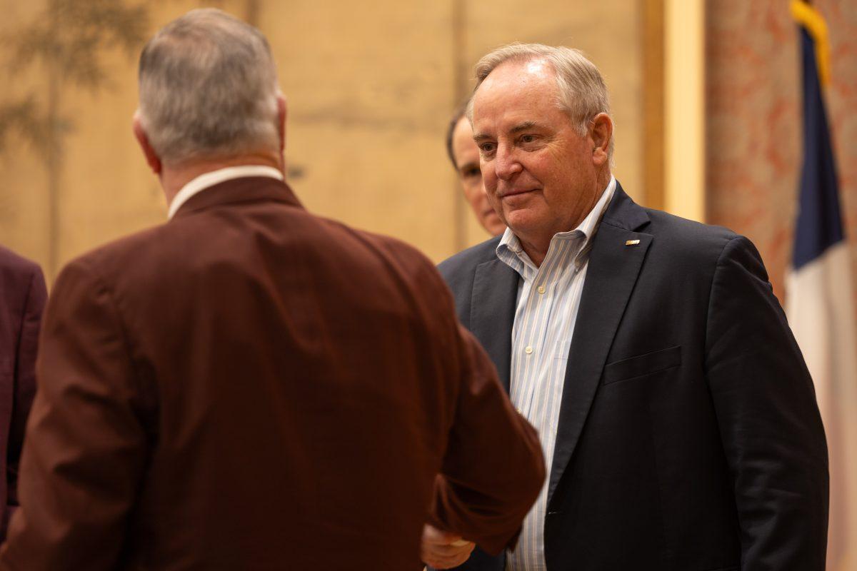 <p>Texas A&M Interim President Mark A. Welsh shakes hands with a university official following the decision naming Welsh as the sole finalist for the title of university president at the Board of Regents Annex on Friday, Nov. 17, 2023. (Chris Swann/The Battalion)</p>