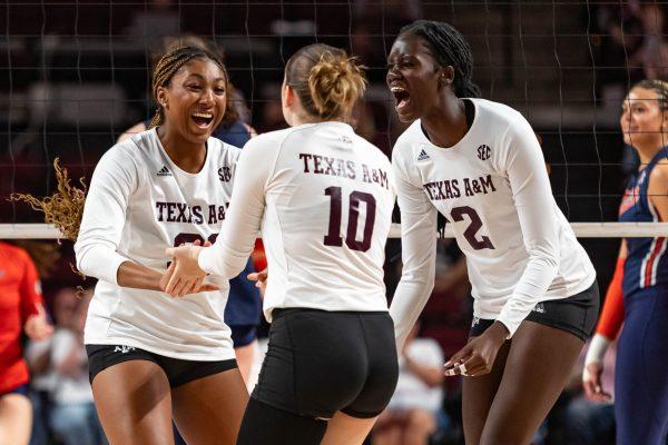 Sophomore MB Morgan Perkins (21) and dreshman OPP Ital Lopuyo (2) celebrate with freshman S Margot Manning (10) after scoring during Texas A&M's game vs. Auburn at Reed Arena on Sunday, Nov. 5, 2023. (Chris Swann/The Battalion)