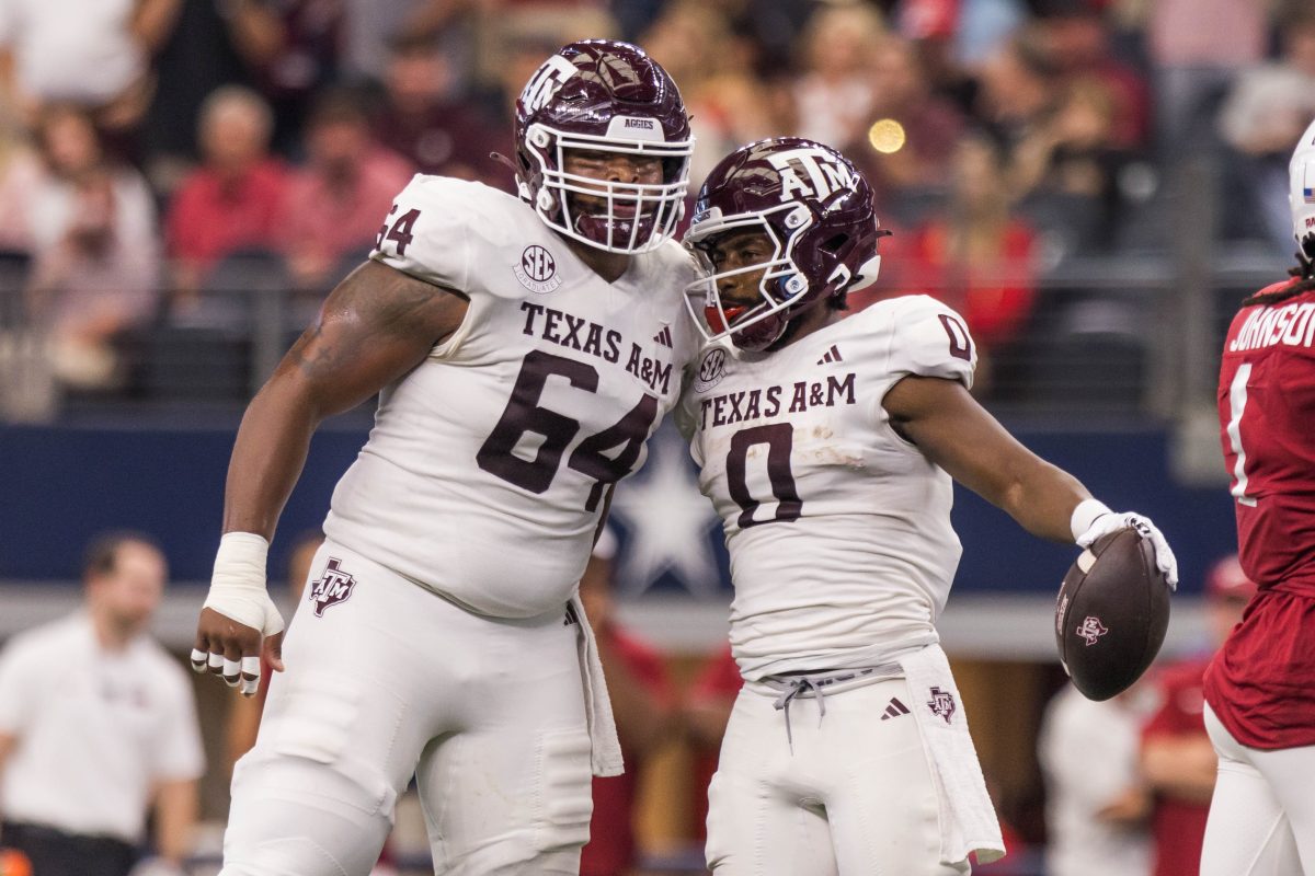Fifth-year OL Layden Robinson celebrates with fifth-year WR Anias Smith after a first-down during the Southwest Classic against Arkansas at AT&T Stadium on Saturday, Sept. 30, 2023. (Chris Swann/The Battalion)