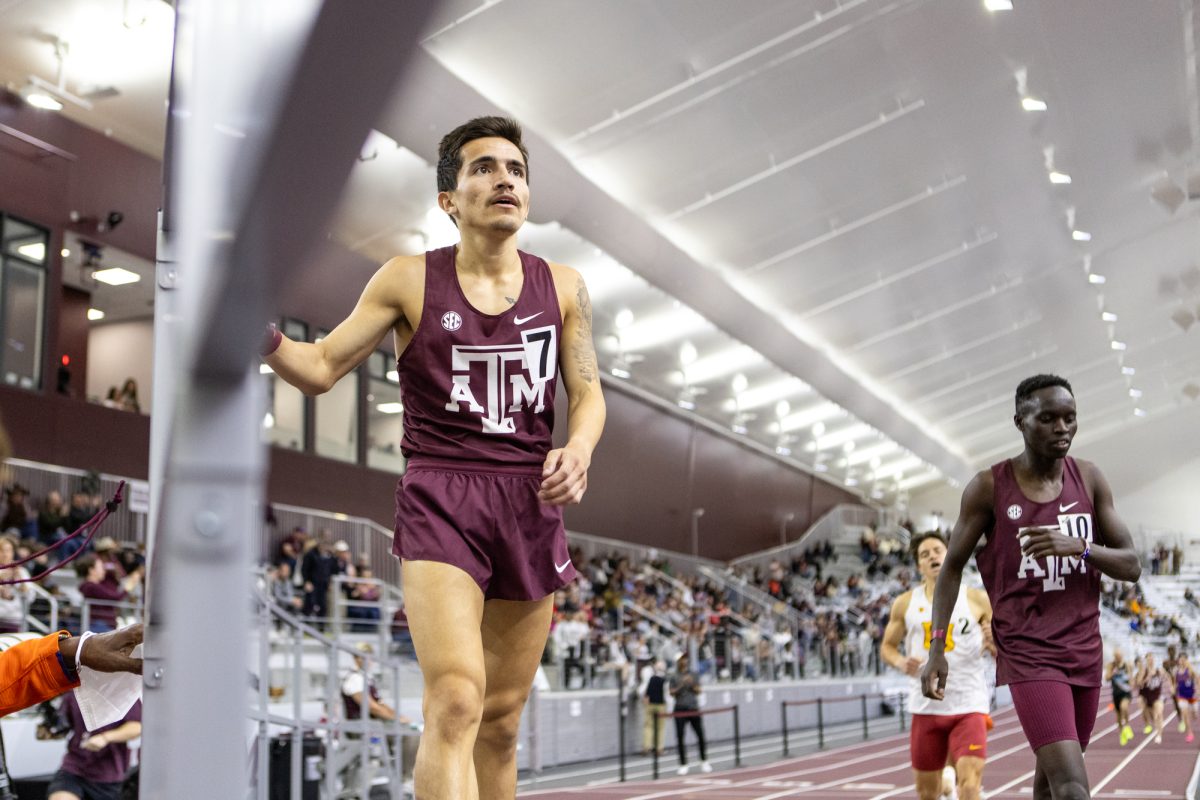 Texas A&M senior Eric Casarez holds the rails after winning the mens 1-mile during the Ted Nelson Invitional at the Murray Fasken Indoor Track on Jan. 20, 2024. (Mattie Taylor/The Battalion)