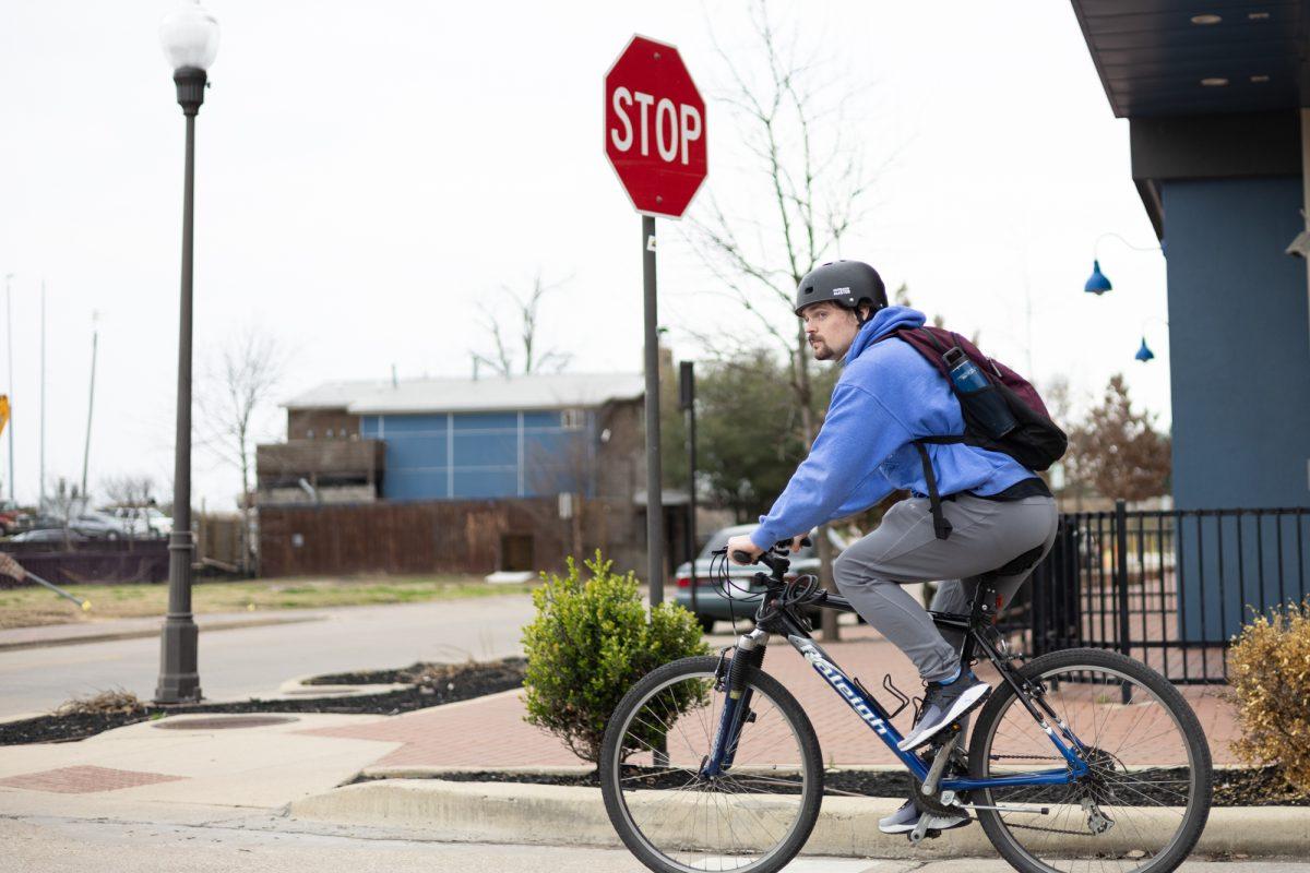 Ocean engineering sophomore Ethan Mills approaches a stop sign on his bike while headed to class on Friday, Feb. 9, 2024. (Adriano Espinosa/ The Battalion)