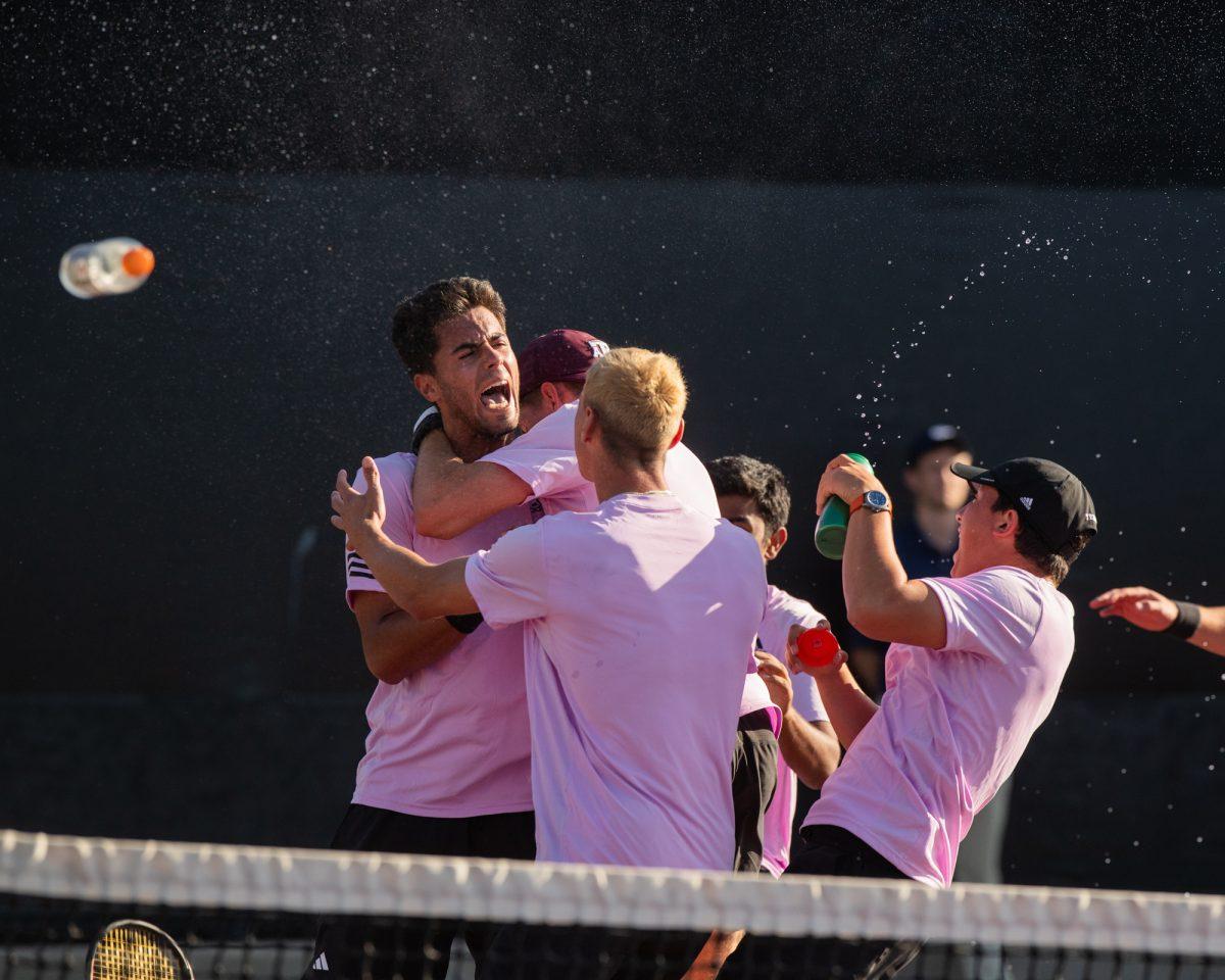 The A&M Mens Tennis team celebrate after Sophomore Togan Tokacs winning set at Texas A&Ms match against Pepperdine on Sunday, Feb. 25, 2024, at the Mitchell Tennis Center. (© Connor May/The Battalion)