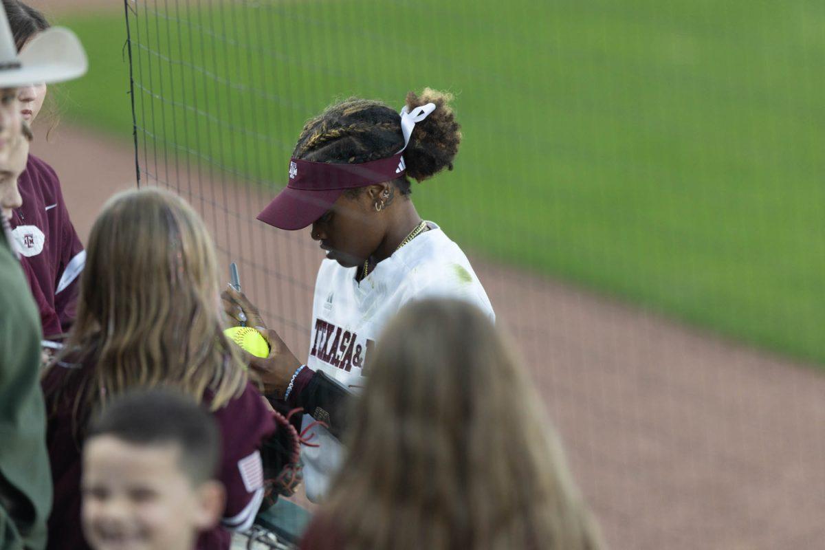 Junior INF Koko Wooley (3) signs balls after Texas A&Ms game against St. Thomas on Feb. 23, 2024 at Davis Diamond. (Jaime Rowe/The Battalion)